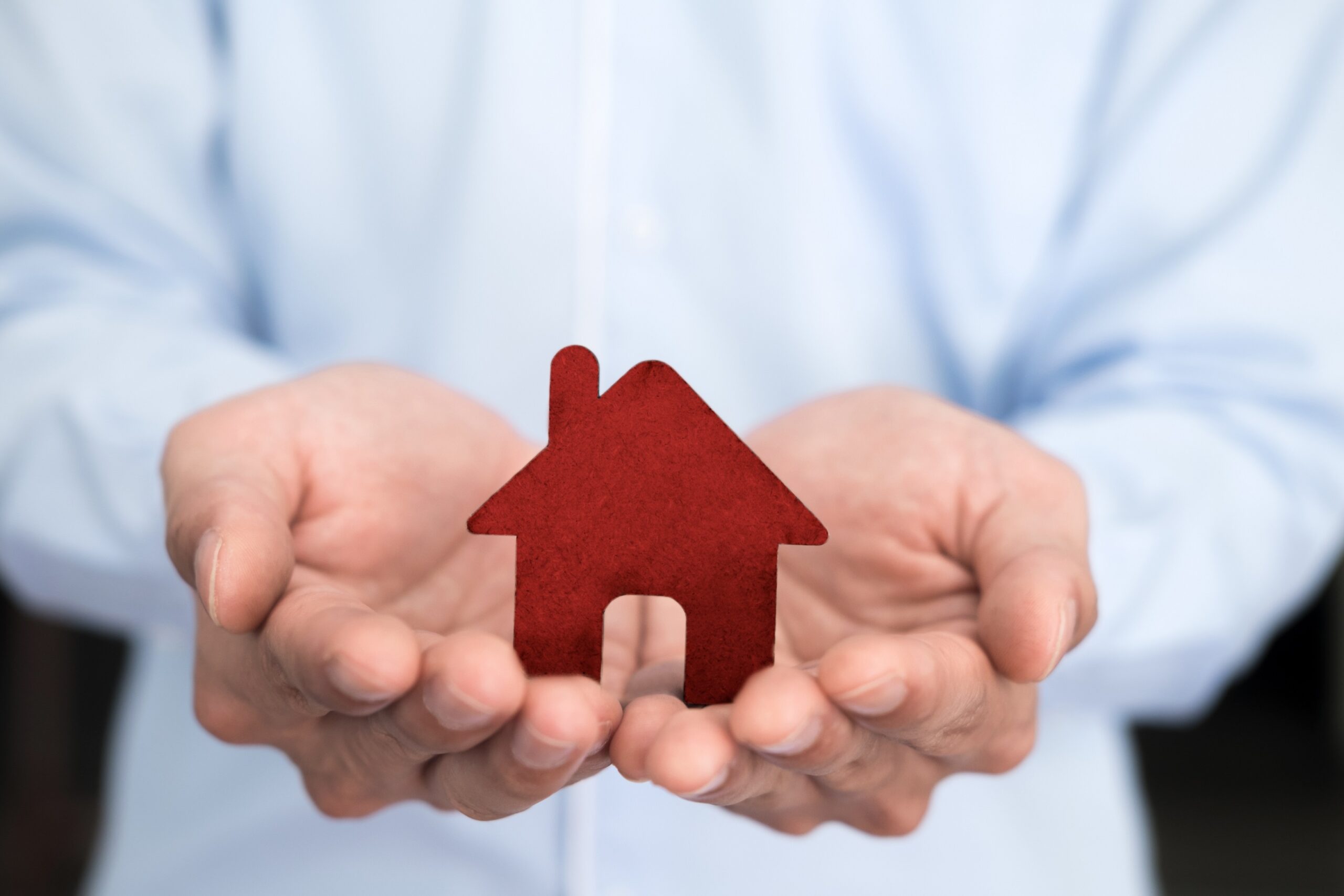 Businessman hand hold the house model saving small house.