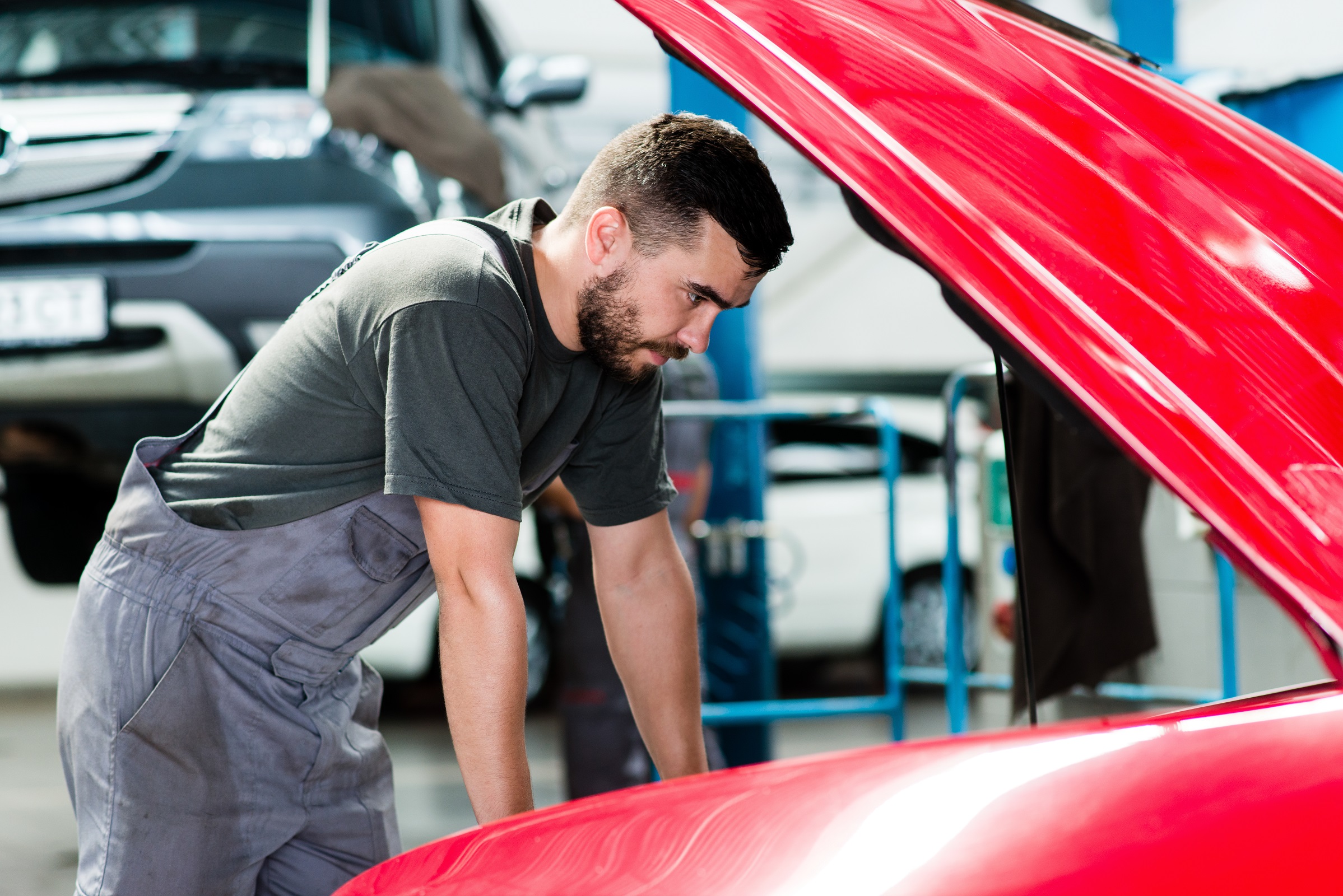 Auto mechanic working in garage. Repair service looking at the c