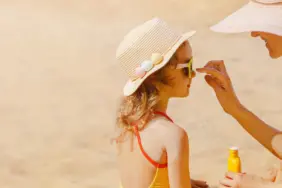 Mom,Carefully,Smears,Her,Child's,Face,With,Protective,Cream,On