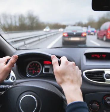 Driving,Car,On,Highway,,Close,Up,Of,Hands,On,Steering