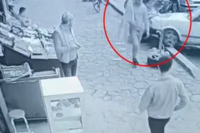 OTOMOBİLİN ALTINDA KALMAKTAN SANİYELERLE KURTULDU, RAHAT TAVIRLARI DİKKAT ÇEKTİ