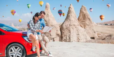 Happy,Couple,With,Map,On,Vacation,By,Car,In,Cappadocia