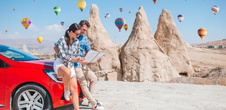 Happy,Couple,With,Map,On,Vacation,By,Car,In,Cappadocia