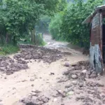 YAĞIŞ SONRASI MAHALLE YOLU ULAŞIMA KAPANDI YAĞIŞ İLE GELEN TAŞ VE ODUN PARÇALARI YOLU KAPLADI