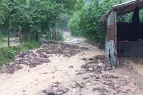 YAĞIŞ SONRASI MAHALLE YOLU ULAŞIMA KAPANDI YAĞIŞ İLE GELEN TAŞ VE ODUN PARÇALARI YOLU KAPLADI