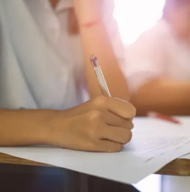 Closeup,To,Hand,Of,Student,Holding,Pen,And,Taking,Exam